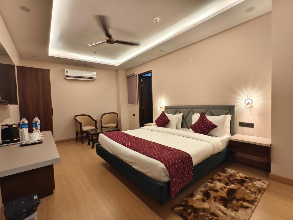 a hotel room with a large bed with a ceiling at Jakk Residency, ILBS Hospital in New Delhi
