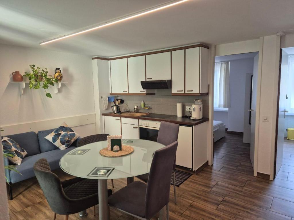 a kitchen and living room with a table and a couch at Casa Rosa in Biasca