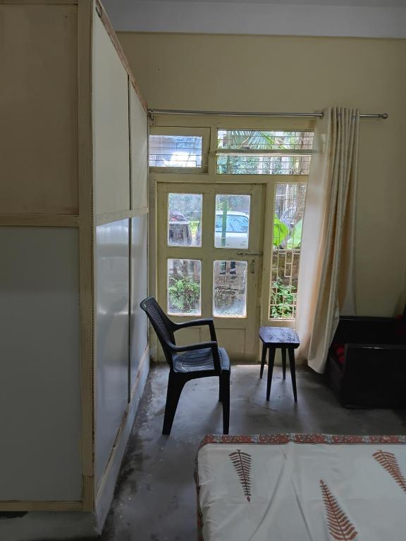 a living room with a chair and a window at Saurabh home stay in Dibrugarh