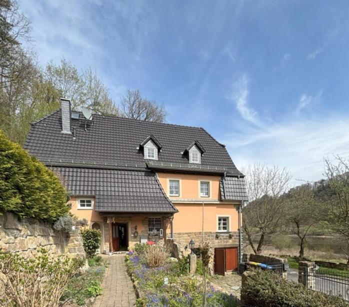 a large orange house with a black roof at Ferienwohnung Fluss & Fels in Stadt Wehlen