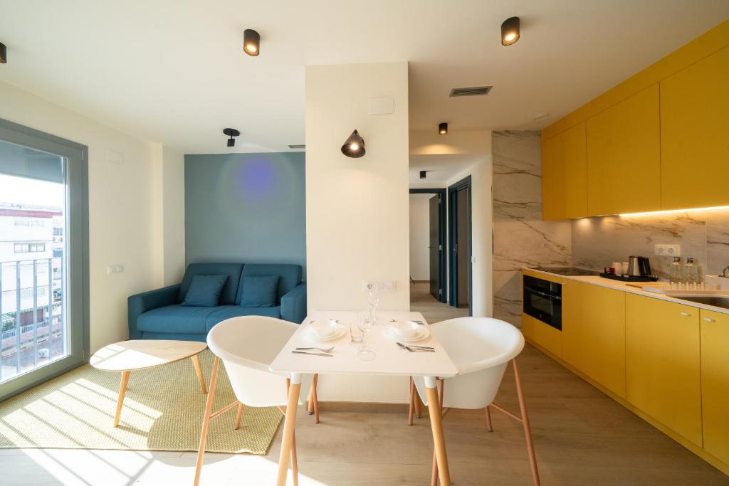 a kitchen and living room with a white table and chairs at Sun & Moon Barcelona Airport in El Prat de Llobregat