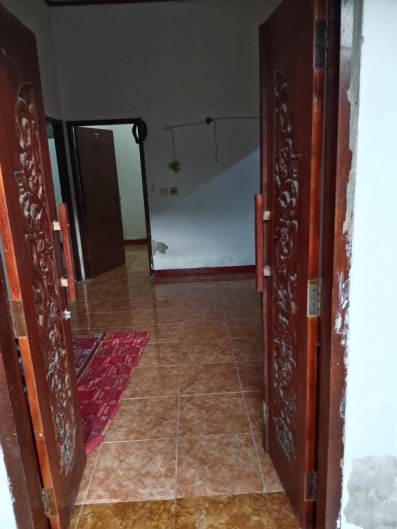 an open door to a room with a bedroom at Kahardi guest house in Sengkol