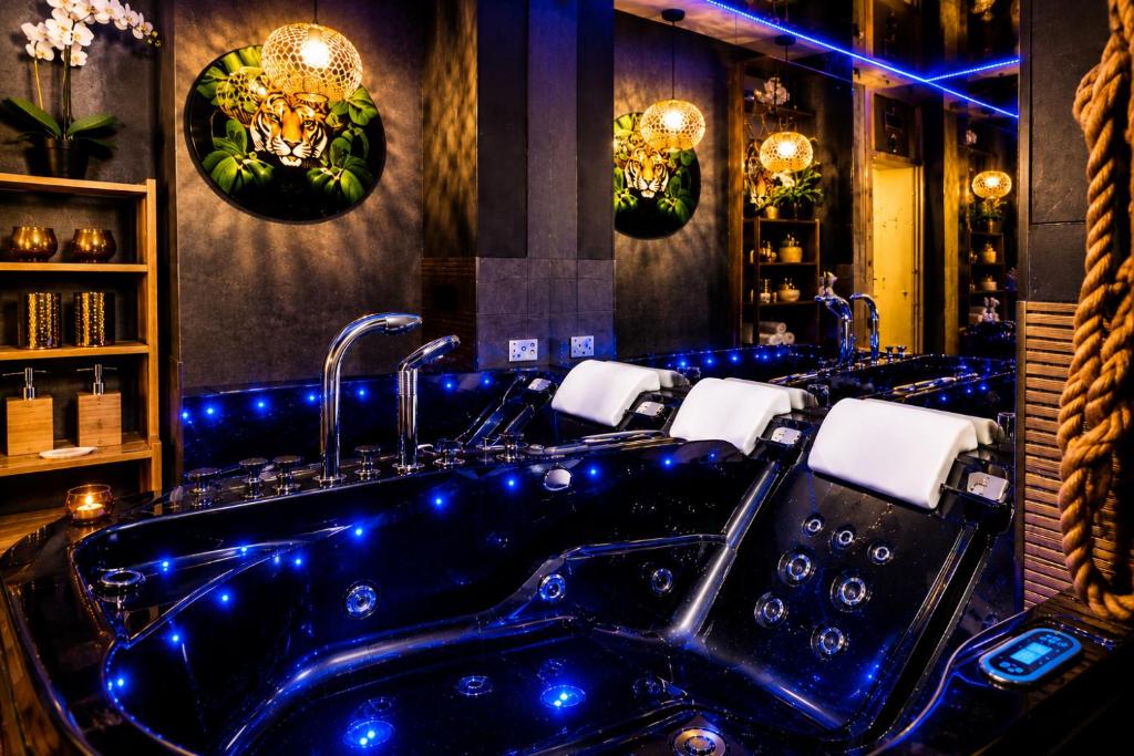 a bathroom with a large tub with blue lighting at JACUZZI & SAUNA Apartament Warszawa Wola in Warsaw