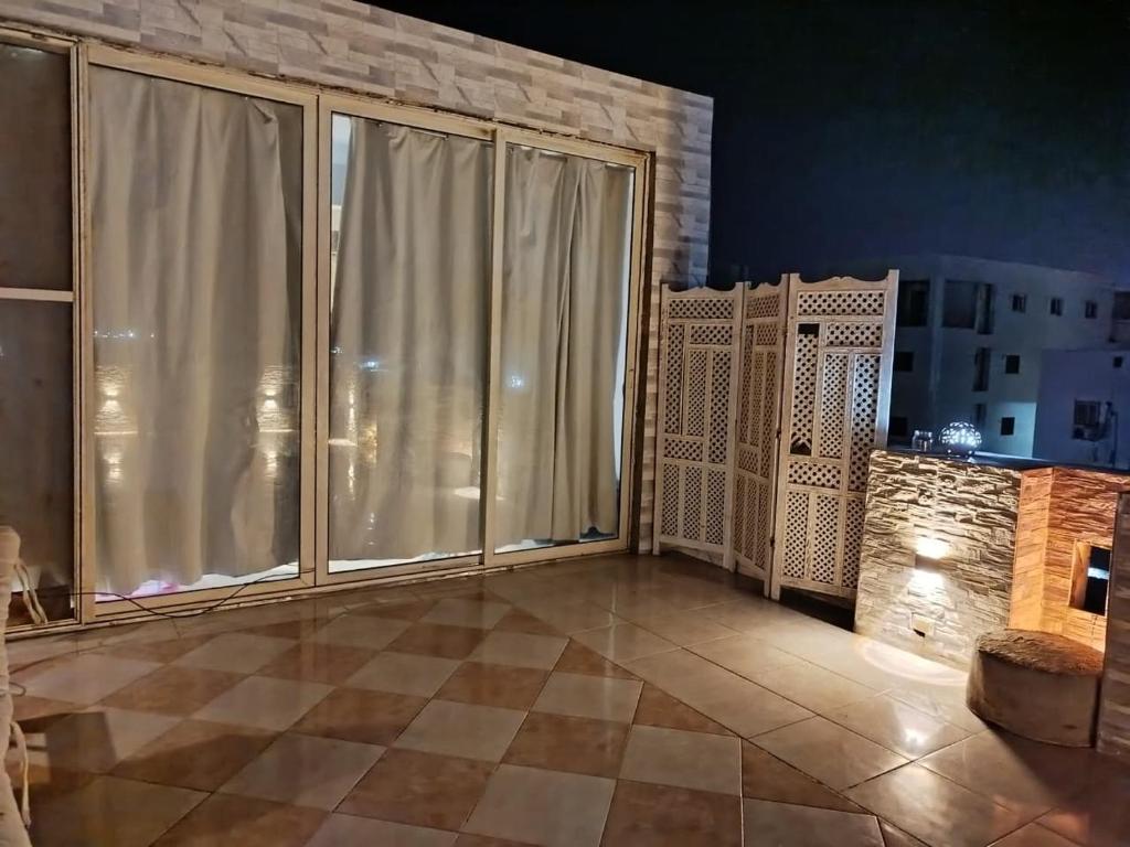 a living room with large windows and a tiled floor at Sky Roof Suite in Marsa Alam City