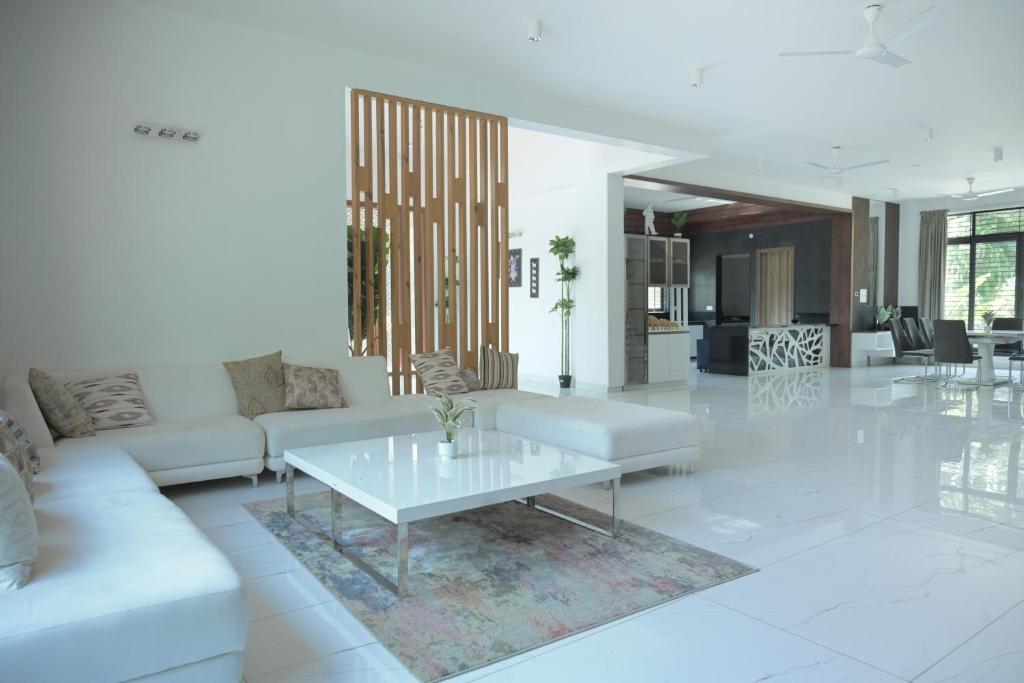 a living room with a white couch and a table at Rare Aura Villa in Dod Jāla
