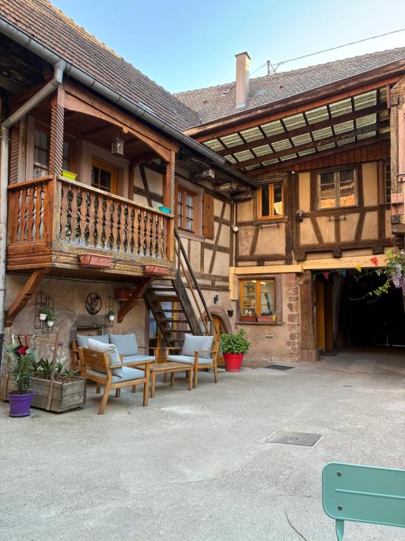 a building with a balcony and tables and chairs at Chez Mamema in Barr