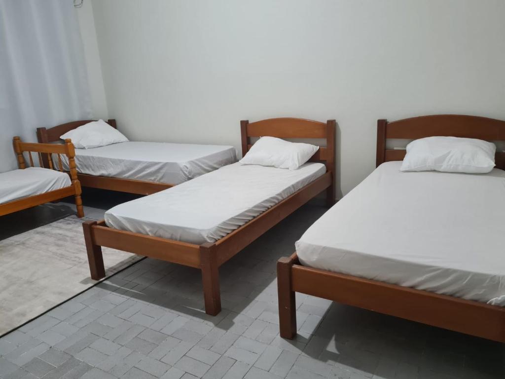 a group of three beds in a room at Beach Hostel do Japa in Ubatuba