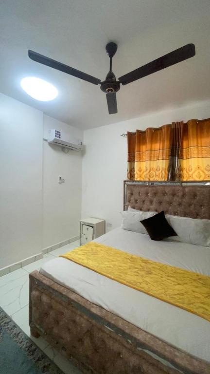 a bedroom with a large bed with a ceiling fan at Mombasa city view in Mombasa
