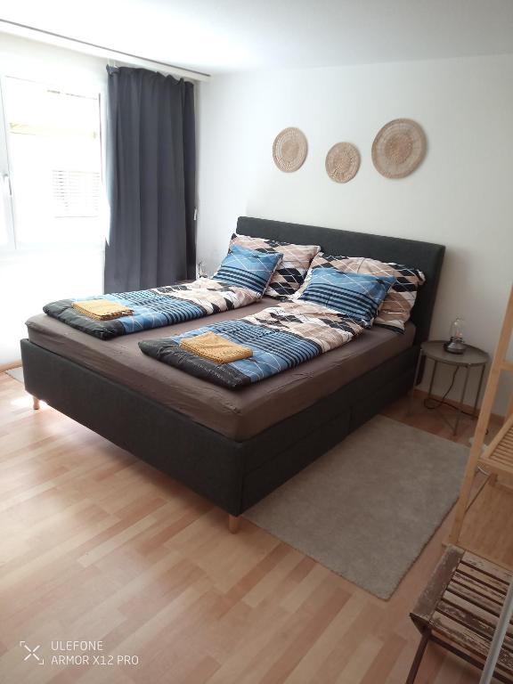 a bed with blue pillows on it in a bedroom at Central 2, nice two room apartment, free bus, city tax included in Lucerne