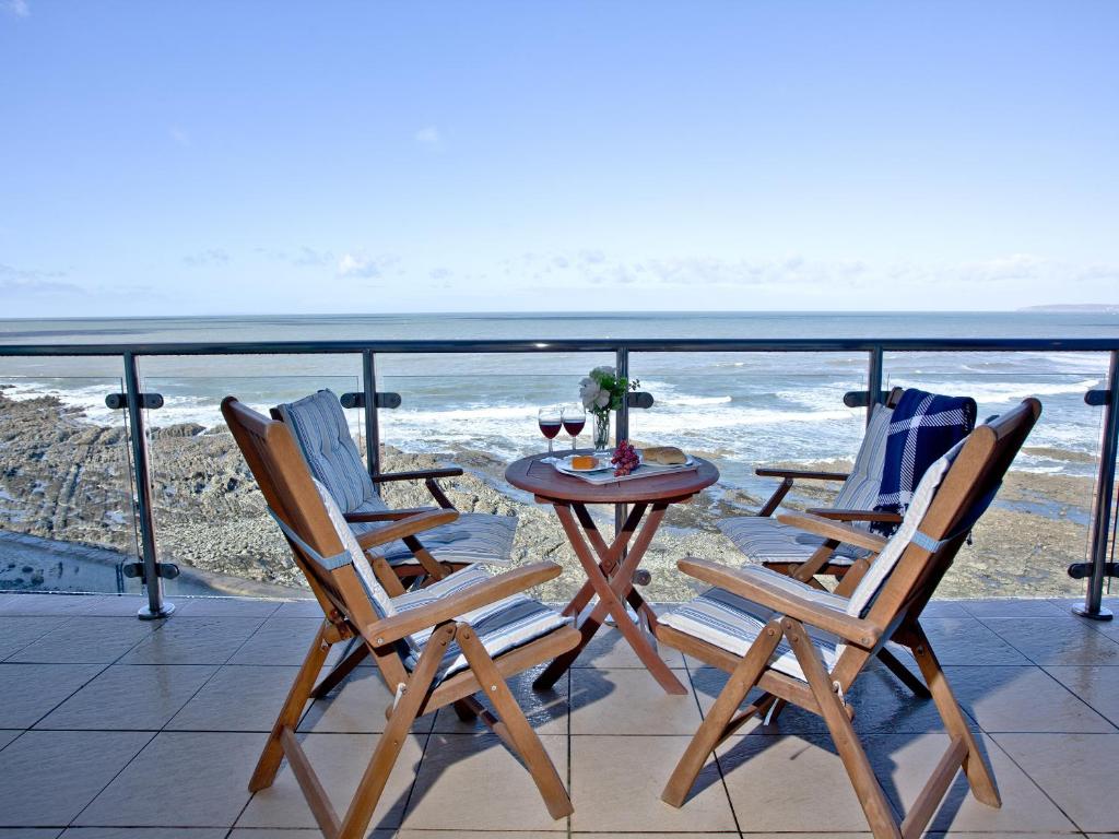 two chairs and a table on a balcony with the ocean at Bliss - Horizon View in Westward Ho