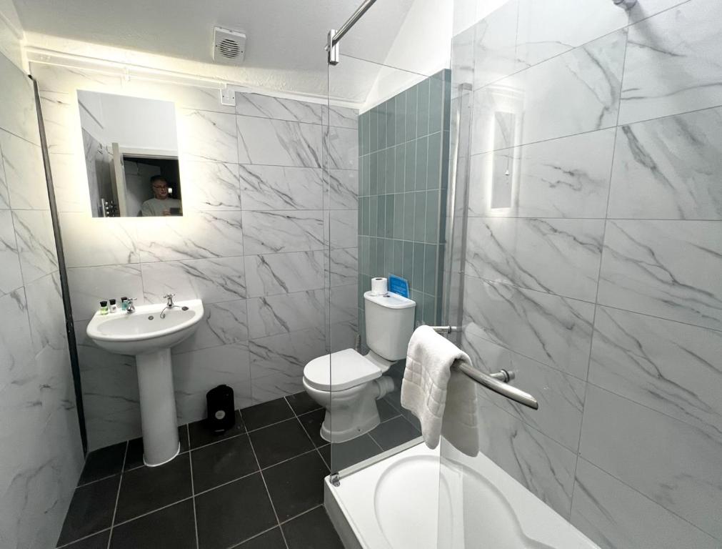 a white bathroom with a toilet and a sink at Stable Cottage 2 in Sedghill