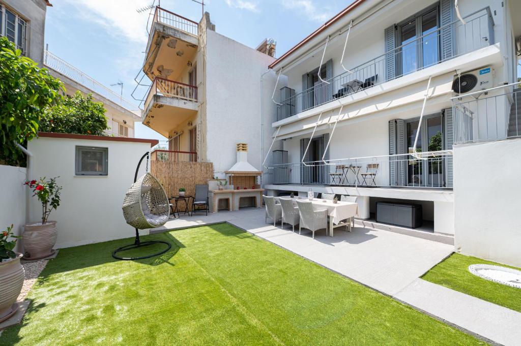 an apartment patio with a lawn in the middle at Villa Yvonni in Poros