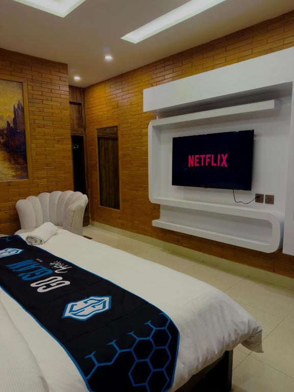 a bedroom with a bed with a television on a wall at Go Glam Hotels Murree in Murree