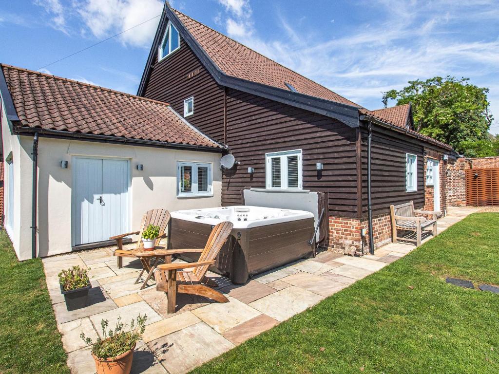 a hot tub in the backyard of a house at Granary Barn in Ashwellthorpe