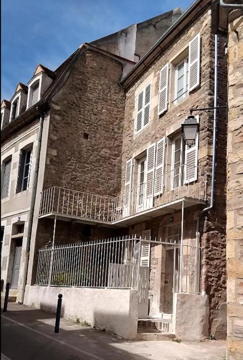 an old brick building with balconies on a street at Le logis de Presle in Avallon