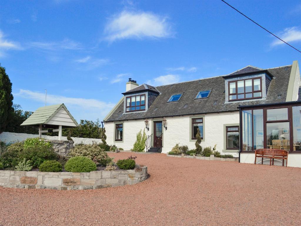 a large white house with glass windows and a patio at Hillend Farm House in Dalry