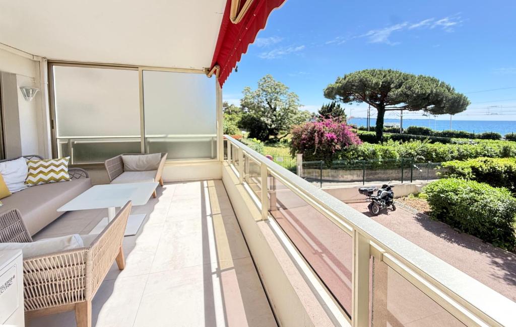 a balcony with furniture and a view of the ocean at Elegant 2 Br with parking in Cannes