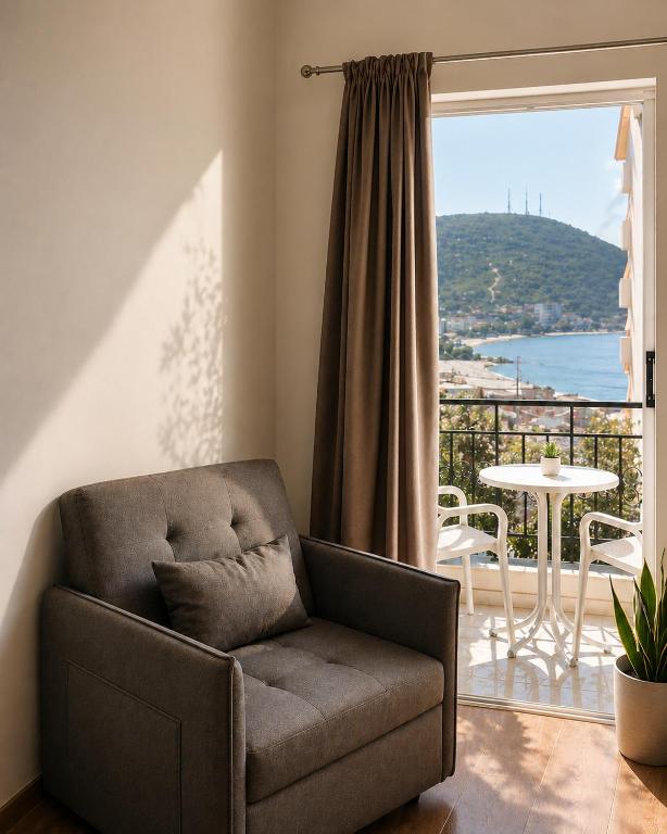 a living room with a chair and a balcony at Duka Rooms in Himare