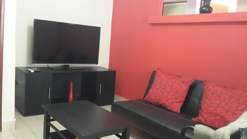 sala de estar con sofá y TV de pantalla plana en Apart Salta en Salta