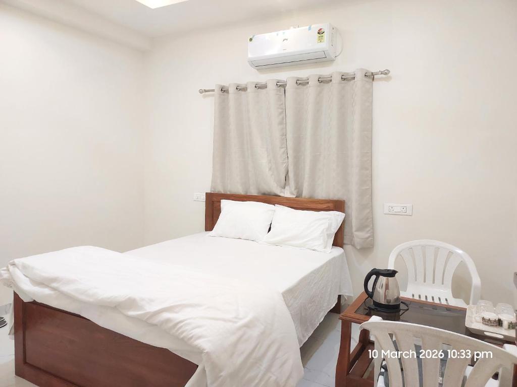 a bedroom with a bed with white sheets at Vishal Lodge in Yermala