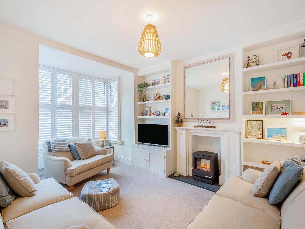 a living room with two couches and a fireplace at Isfryn in Llanbedr