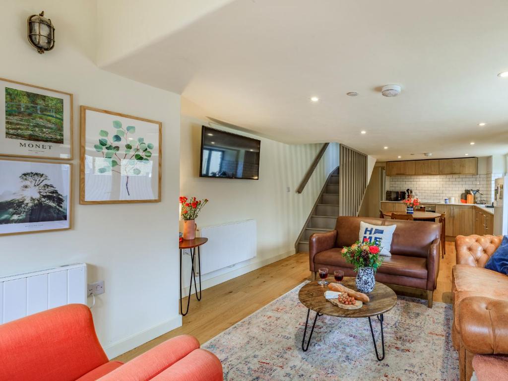 a living room with a couch and a table at Coach House - Uk32202 in Burton Bradstock