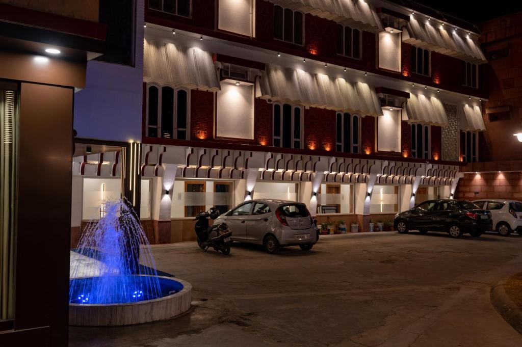 a fountain in front of a building at night at Hotel Bobina in Gorakhpur