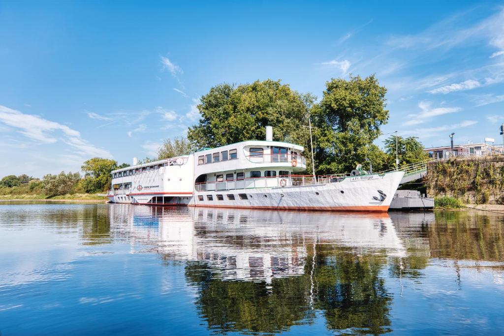 a large boat is docked on the water at Schiffshotel Böttger in Dresden