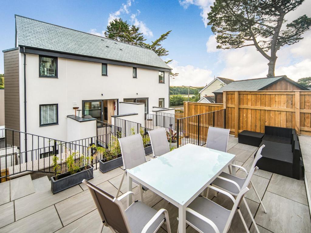 a patio with a white table and chairs at Puckoo's Nest in Newquay
