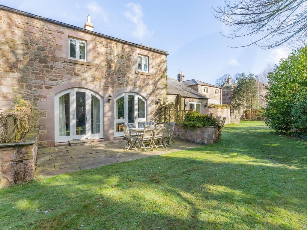 an external view of a stone house with a patio at Carriage House - Uk49288 in Preston