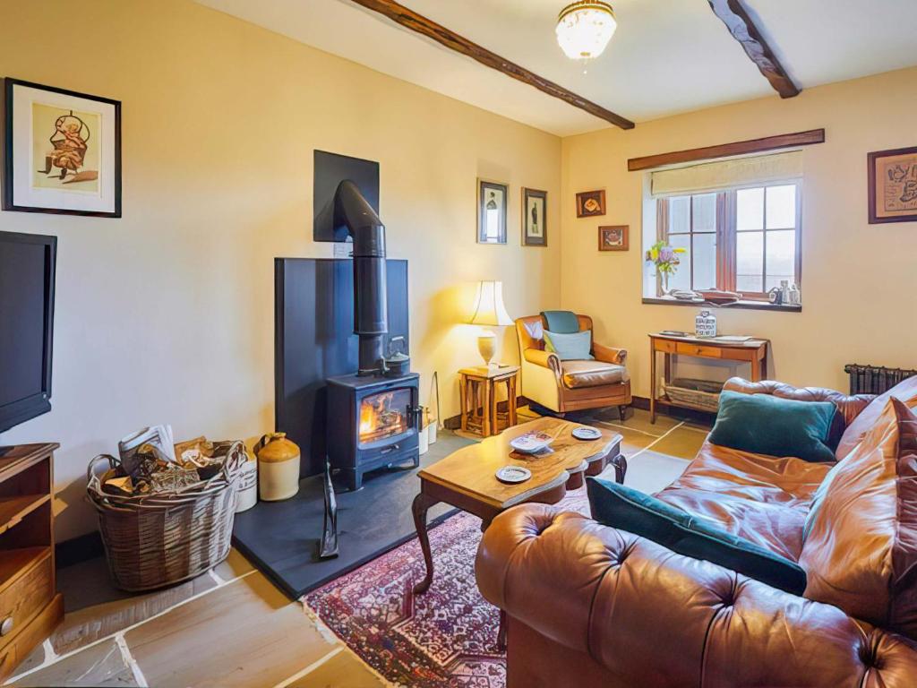 a living room with a couch and a fireplace at Rustic Retreat in Llangadog