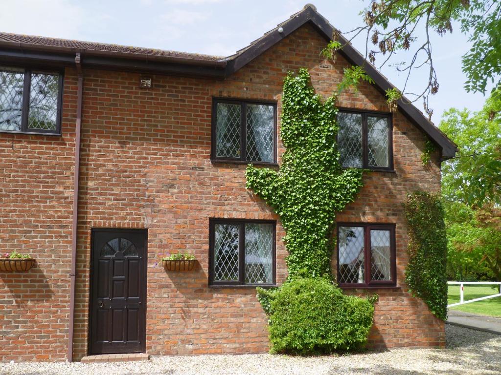 a brick house with ivy on the side of it at Hayloft-E2699 in Winthorpe