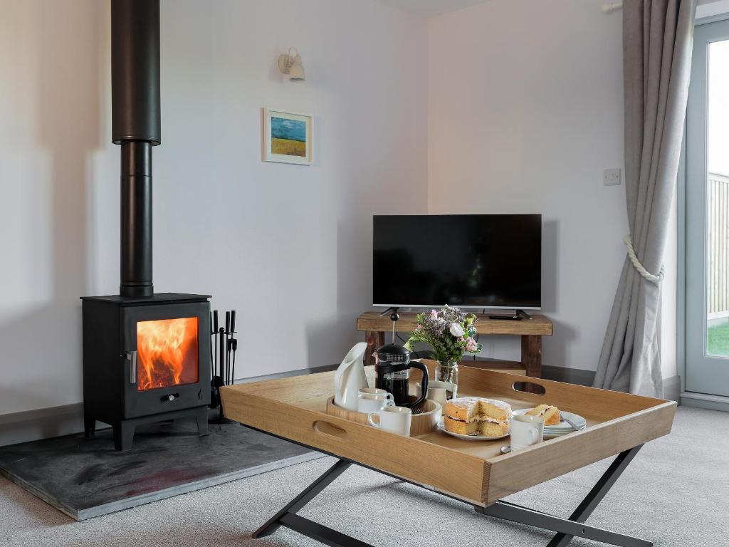 a living room with a stove and a table with food at The Maddocks - Uk36311 in Whitchurch