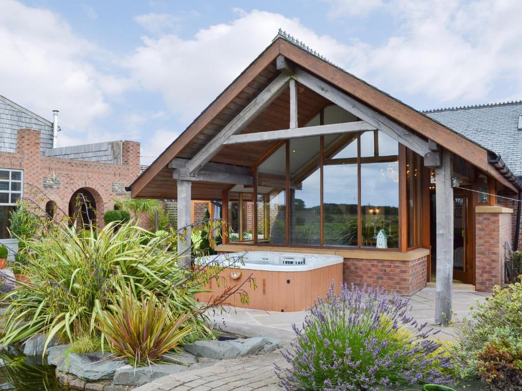 a pavilion with a hot tub in a garden at Carr End Barn A in Preesall