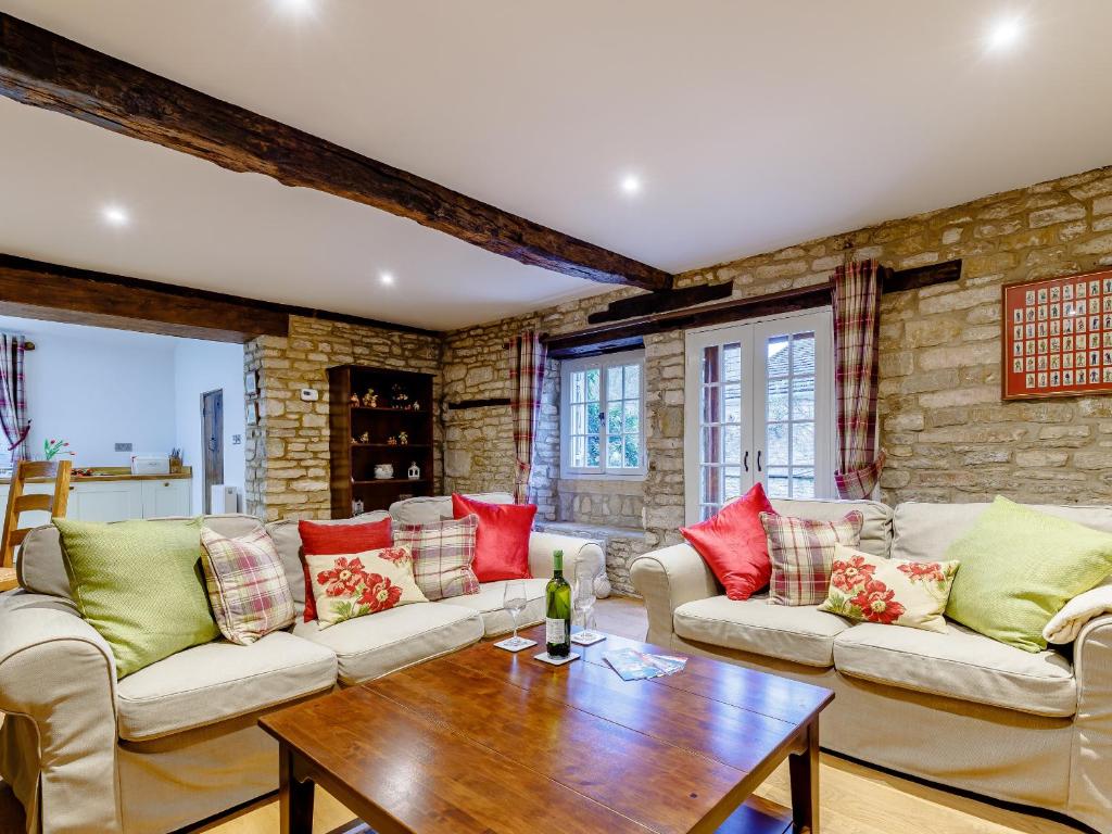 a living room with two couches and a wooden table at Kilcot Coach House in Hillsley