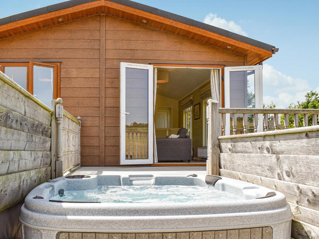 a hot tub on the patio of a house at Buckland Lodge in Pentridge