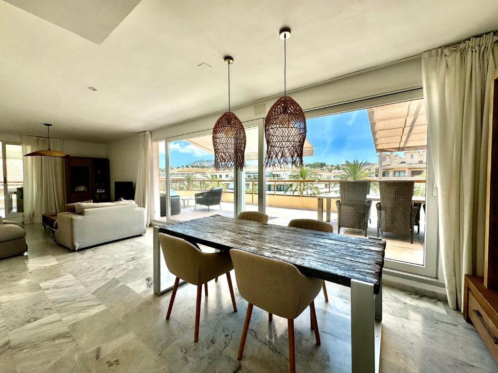 a dining room with a table and chairs and a large window at Penthouse Seven Oceans Moraira in Moraira