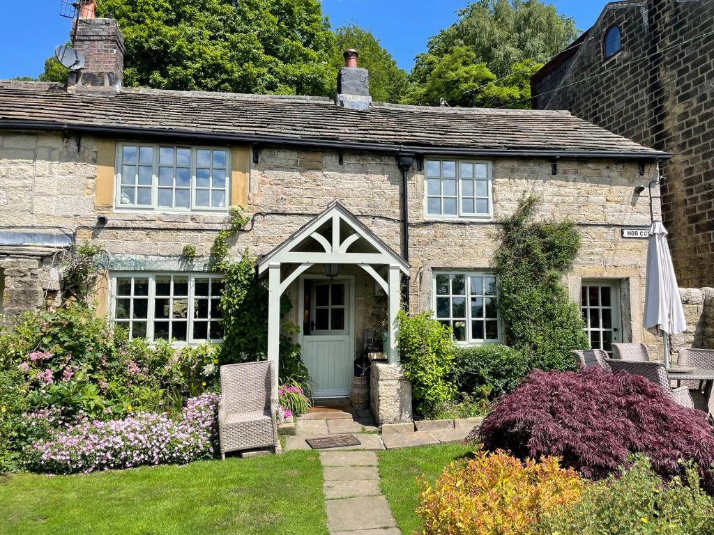 an old stone house with a green door at Hob Cote - Cottage in Heptonstall