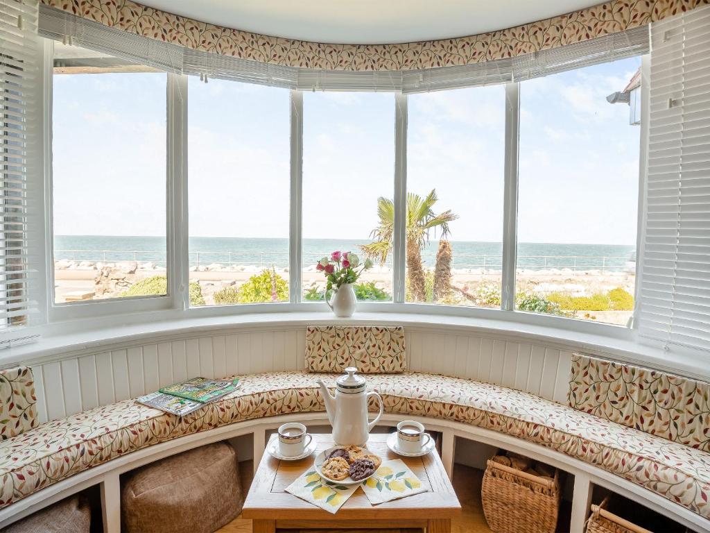 a bench in a room with a view of the beach at Waterside in Llandrillo-yn-Rhôs