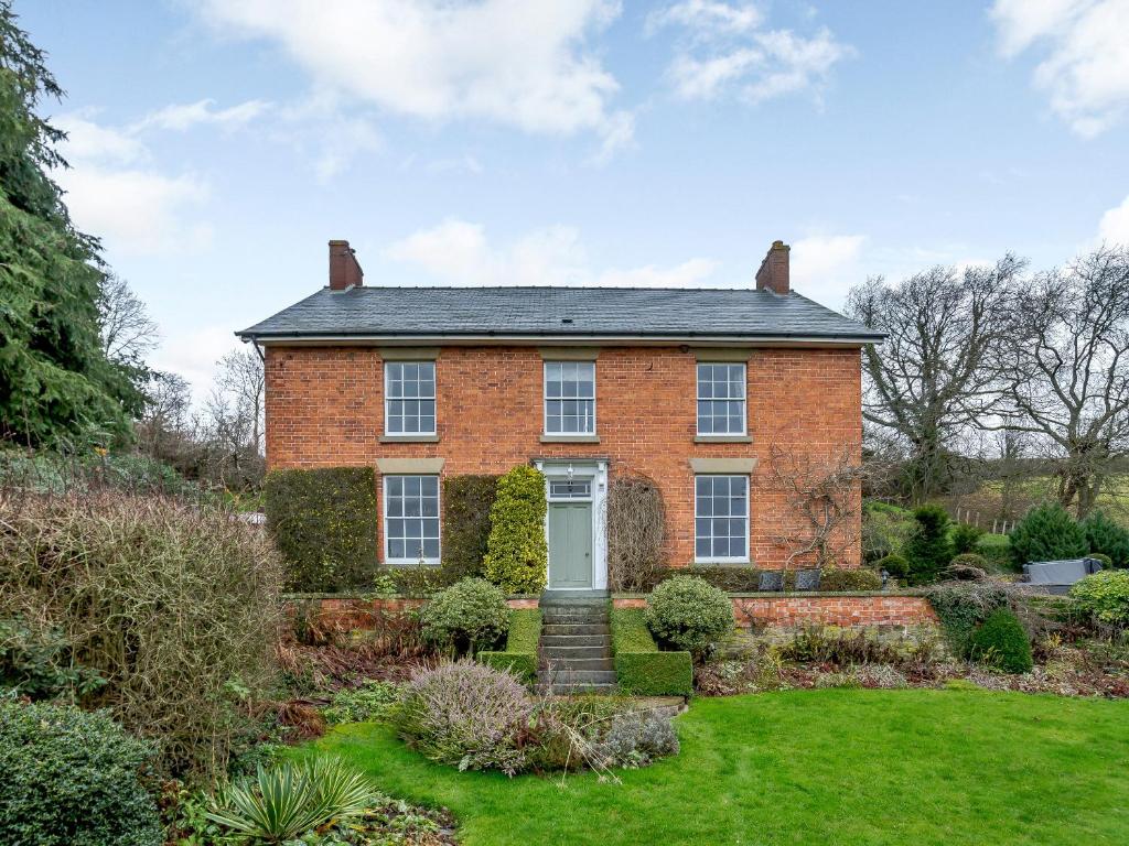an old brick house with a garden in front of it at Old Upper Gwestydd in Highgate