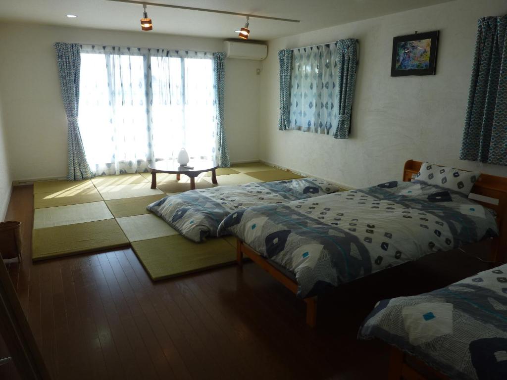 ein Schlafzimmer mit zwei Einzelbetten und einem Fenster in der Unterkunft Sora-mame in Yakushima