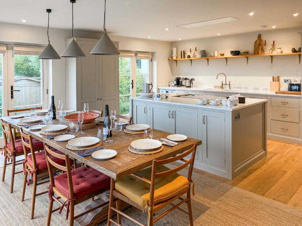 a large kitchen with a wooden table and chairs at Cairn Ryan in Saint Mawes