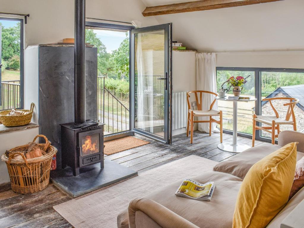 a living room with a wood stove and a patio at The Granary - Uk50401 in Llanstephan