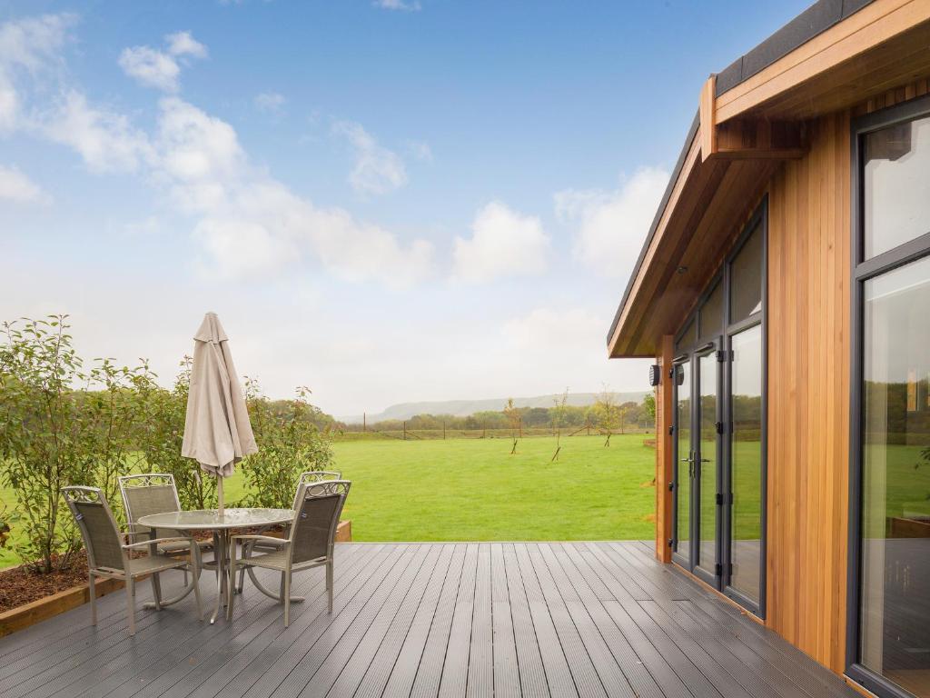 a patio with a table and chairs on a deck at Cedar Lodge in Hassocks