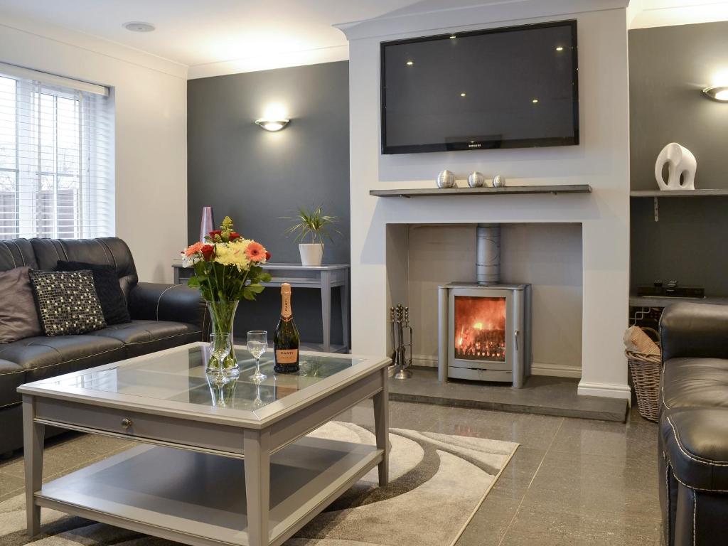 a living room with a couch and a fireplace at Oswald House in Llansantffraid