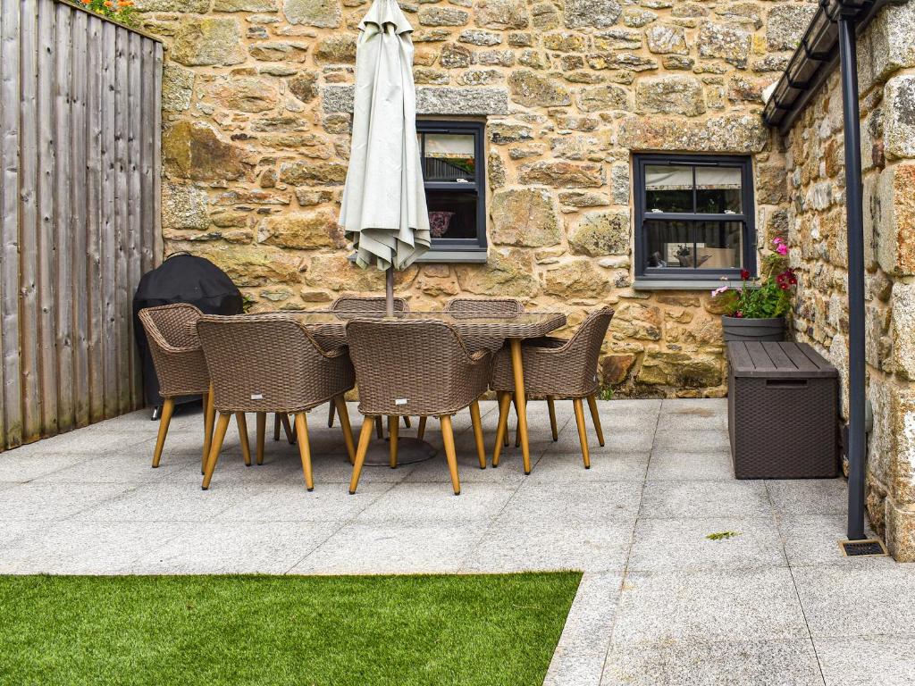 a table and chairs with an umbrella on a patio at Midge in Newlyn