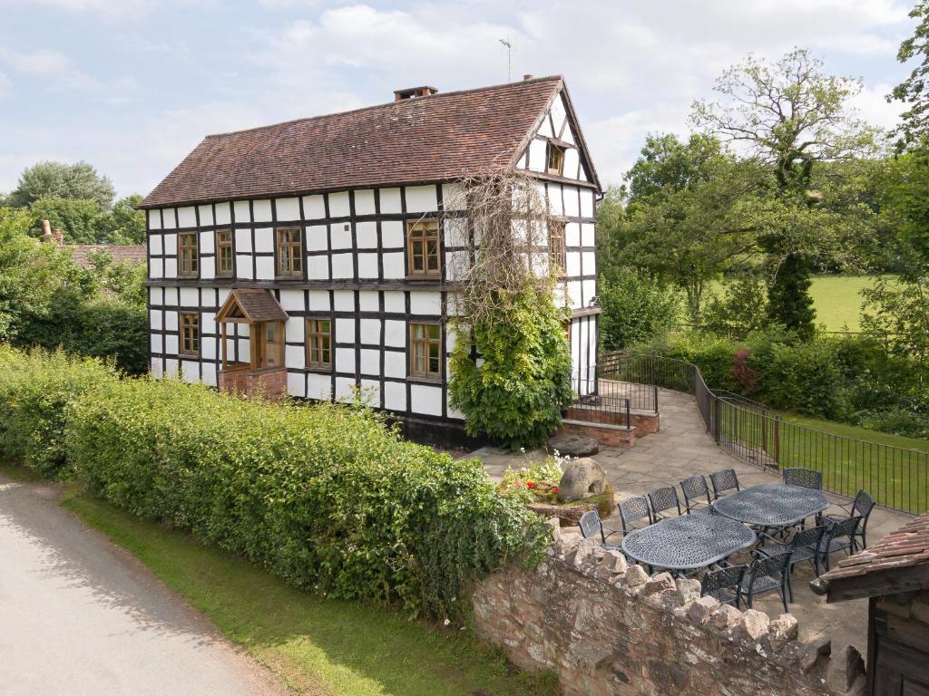 a house with a table and chairs in front of it at Brook House in Mathon