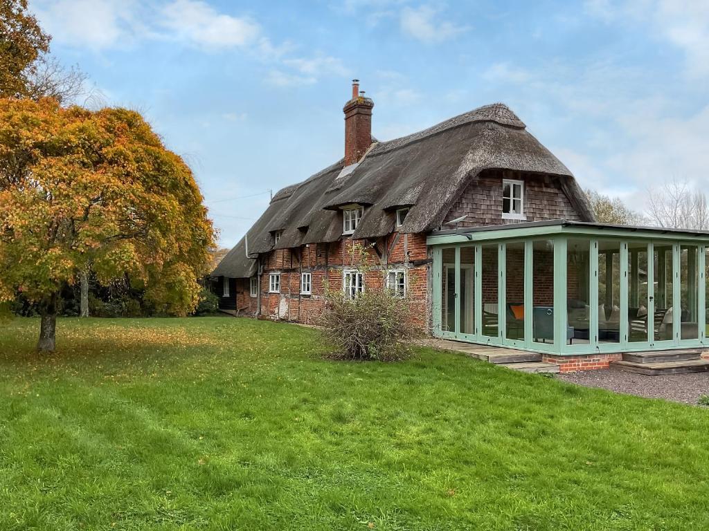 an old brick house with a thatched roof at Smallbrook Cottage - Uk50922 in Salisbury