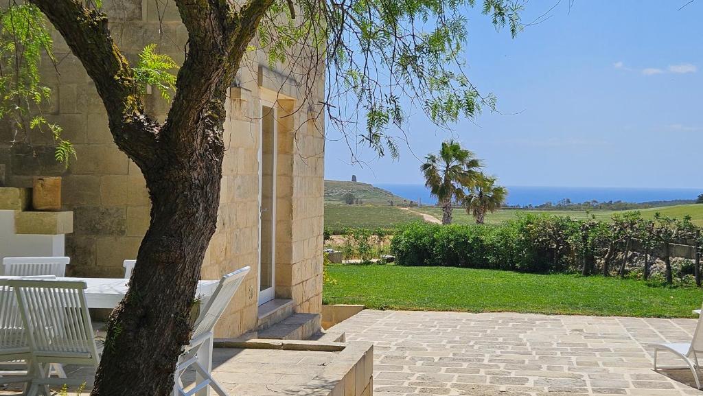 a tree sitting next to a building with a patio at Antica dimora "Nicole e Cristiano" in Otranto