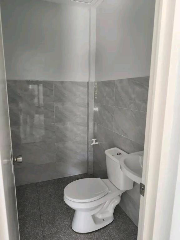 ein Badezimmer mit Toilette und Waschbecken in der Unterkunft Andrea's apartment in Balayan
